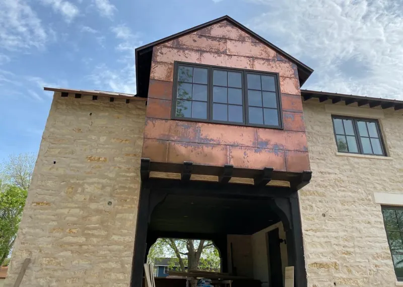 Copper metal panel facade on a stone building for Roof Repair in Cypress